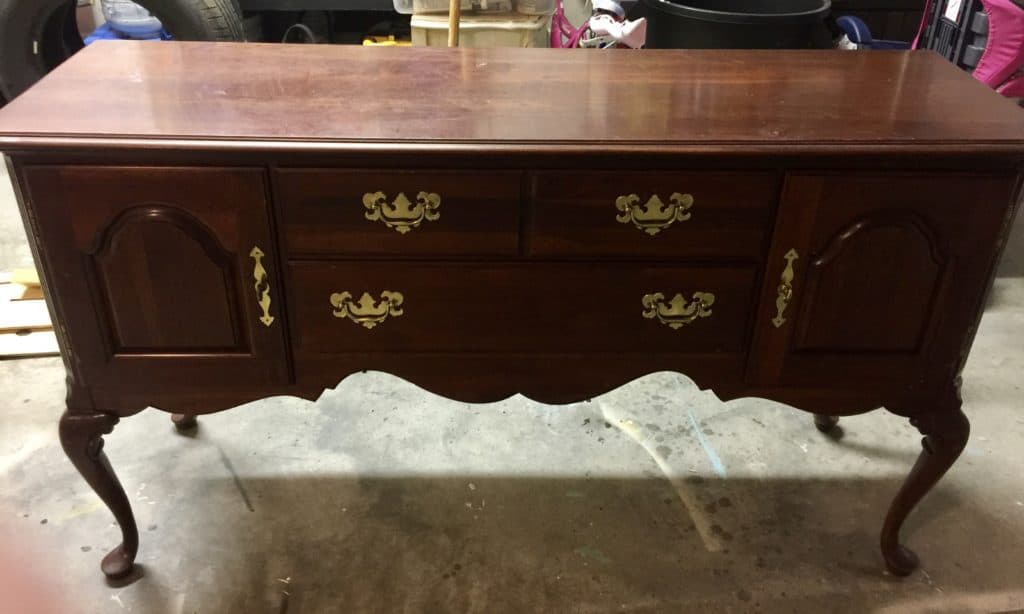 An old dark wood buffet before a makeover with paint.