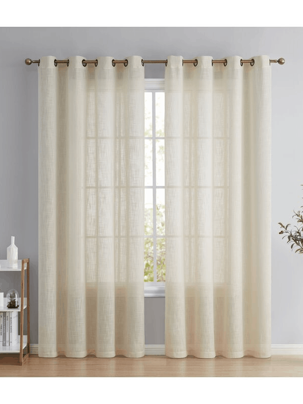 Sheer cream-colored curtains hang in front of a large paned window. 