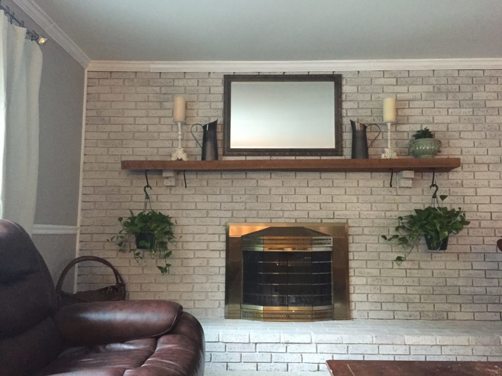 After image of a fireplace makeover with whitewashed bricks.