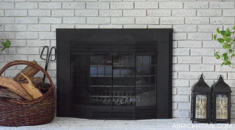 A whitewashed fireplace with a painted black fireplace surround.