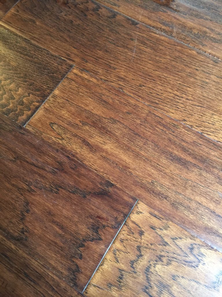 A picture of dark wood flooring showing how to fix a scratch.