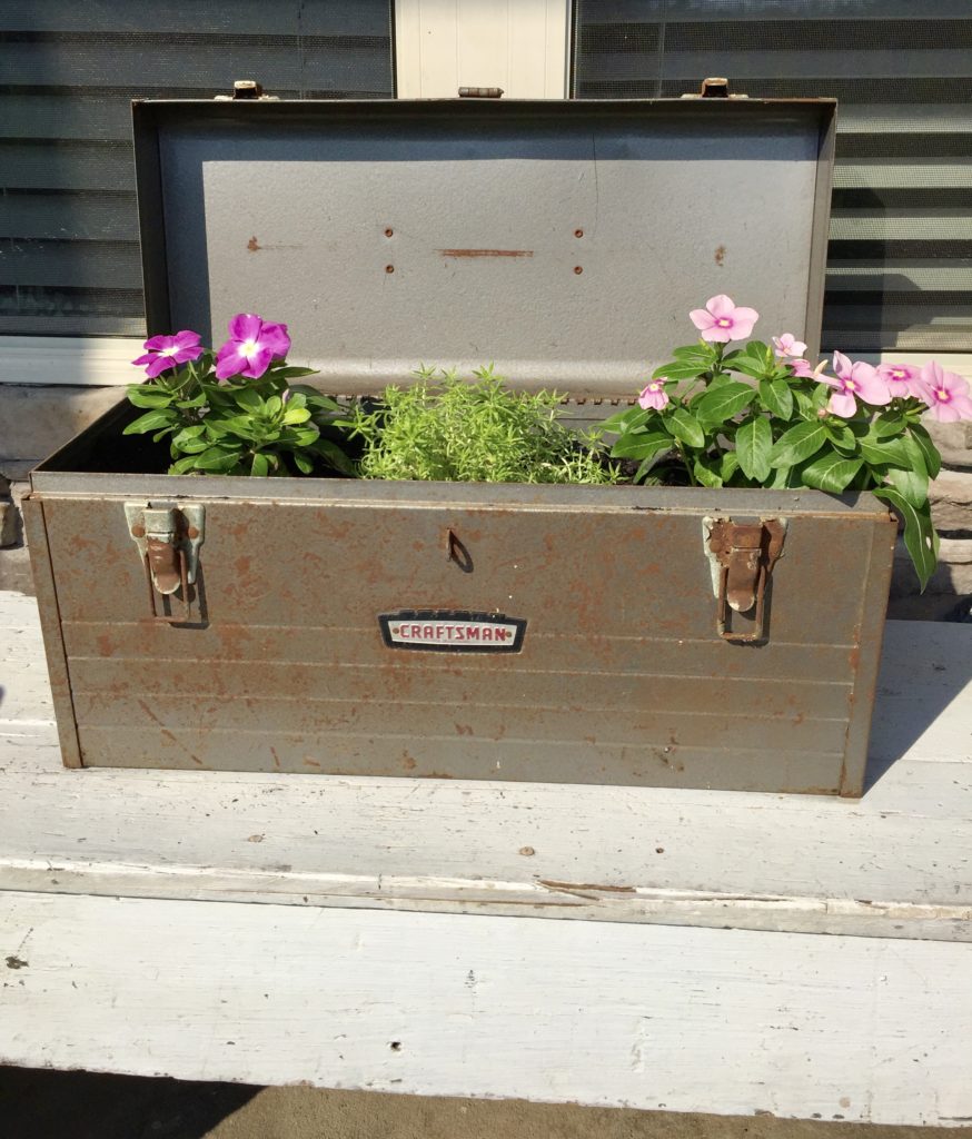 A planter made from an old craftsman toolbox on a porch.