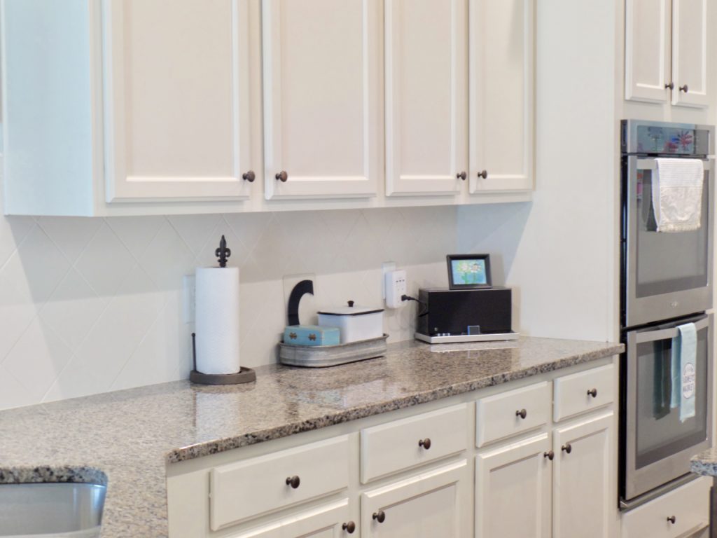 A section of cabinets in a kitchen that have been painted white.