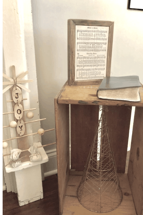 A homemade wooden Christmas tree decorations next to a wooden crate.