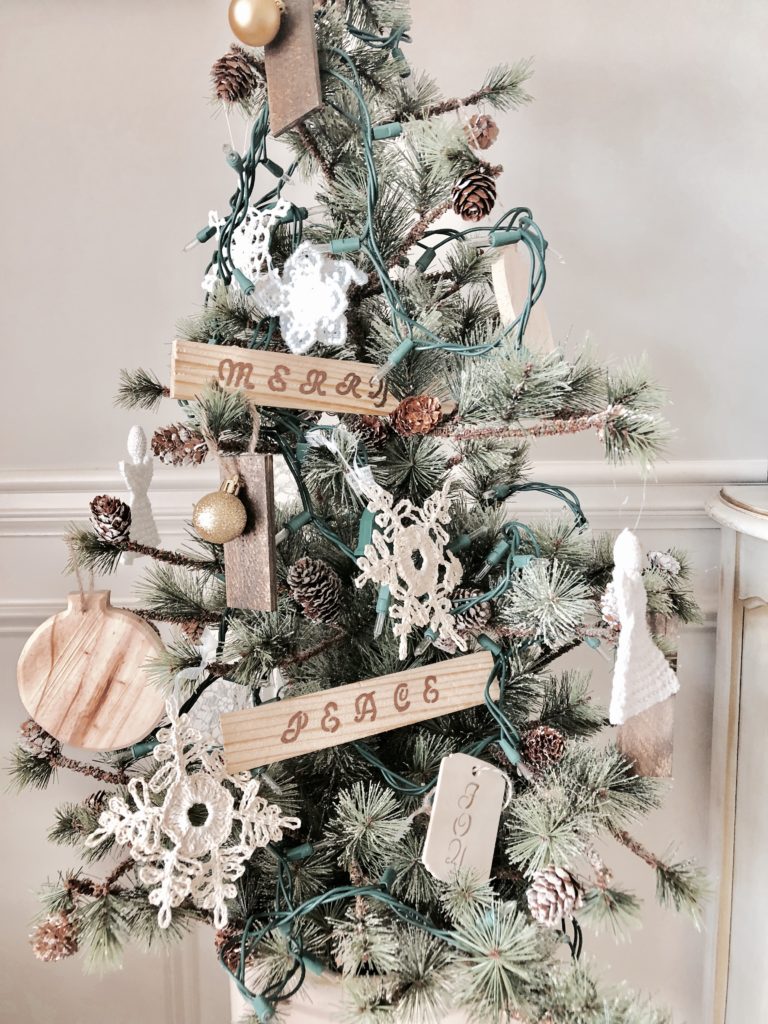 A small Christmas tree with DIY wooden ornaments in a dining room.