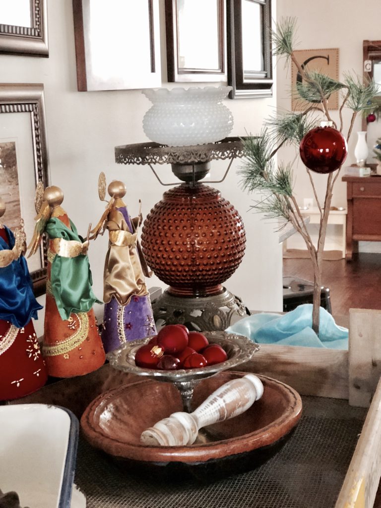 Christmas angel figurines on an entryway table surrounded by vintage decor.