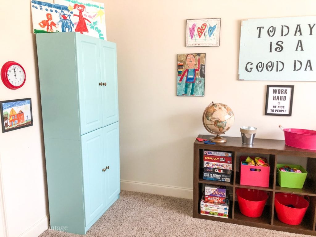 Painted cabinet and organized shelves in a kid's room.