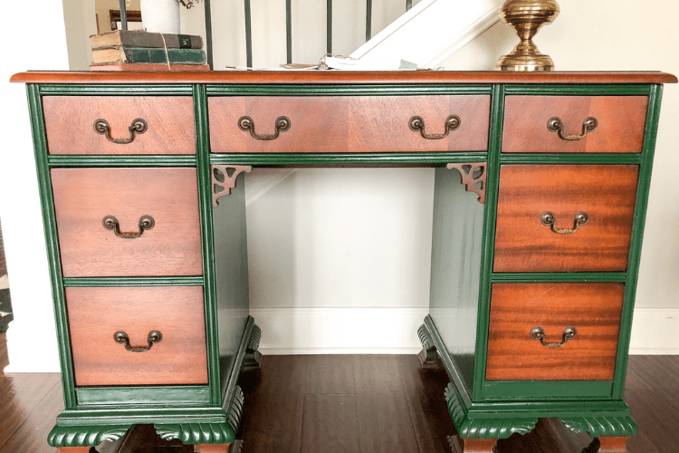 Vintage green and wood desk next to stairs in a house.