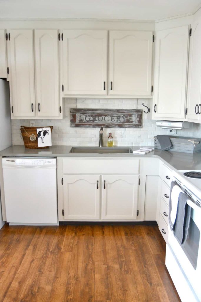 A kitchen with creamy white cabinets and a gray countertop.