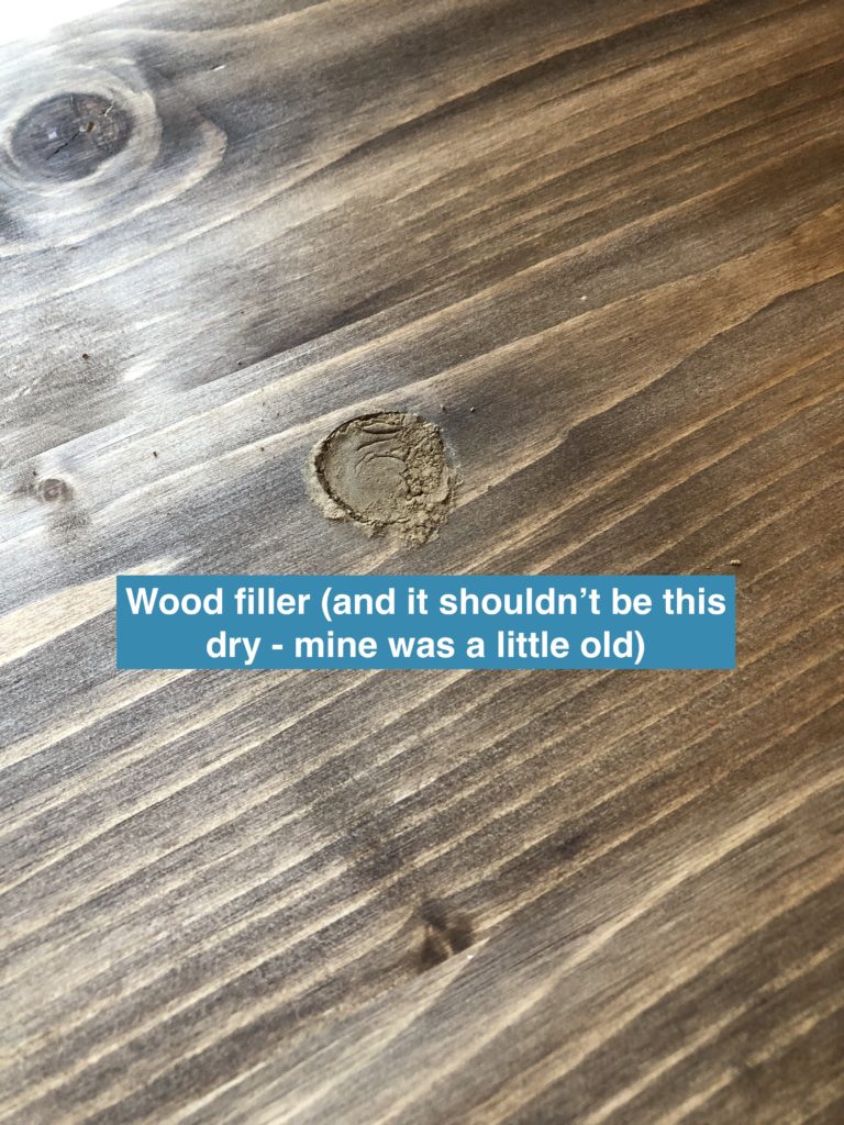 Wood filler filling a hole in a desk