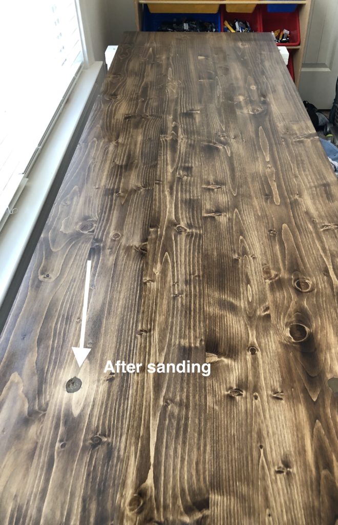 Wood filler covering a hole in a desk after sanding