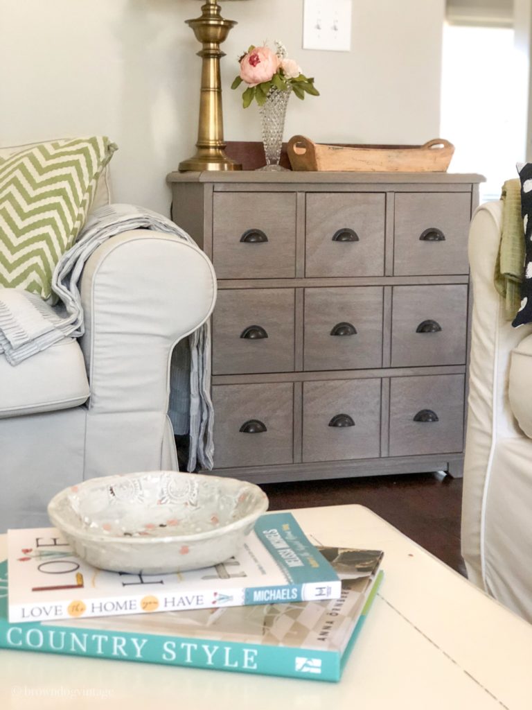 Living room setting with a coffee table and books and a side table with decor.