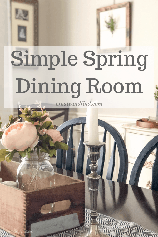 Pinterest graphic with text that reads \"Simple Spring Dining Room\" with a picture of a dining table with pink flowers in a glass vase as the background.