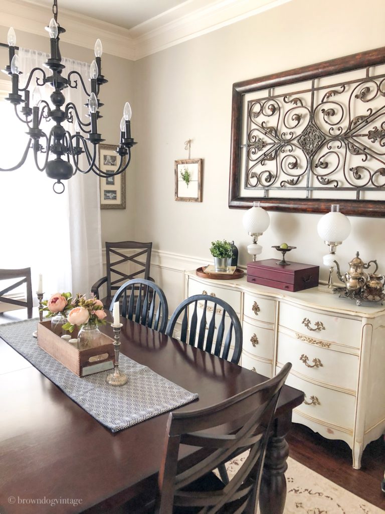 A farmhouse dining room with a side table decorated for spring.