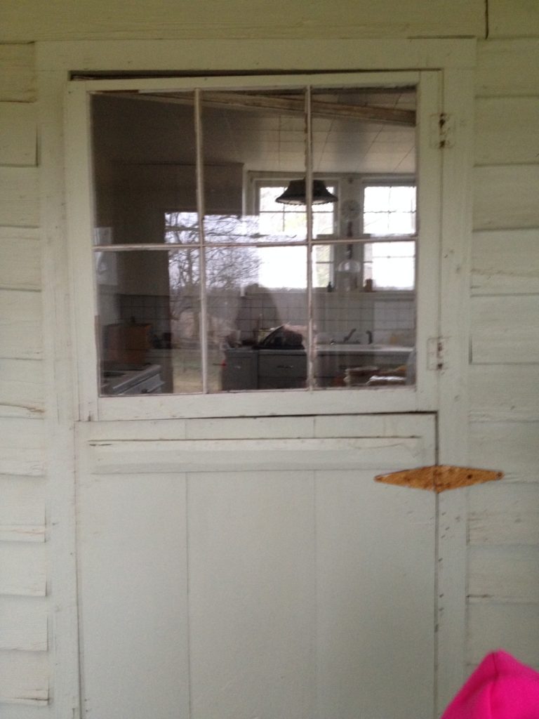 A Dutch-style farmhouse door on an old white house.