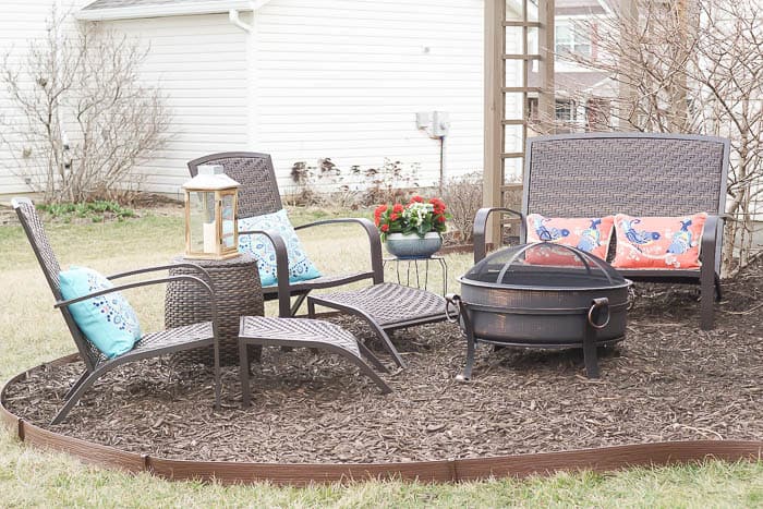 DIY outdoor fire pit area with seating and and mulch ground cover.