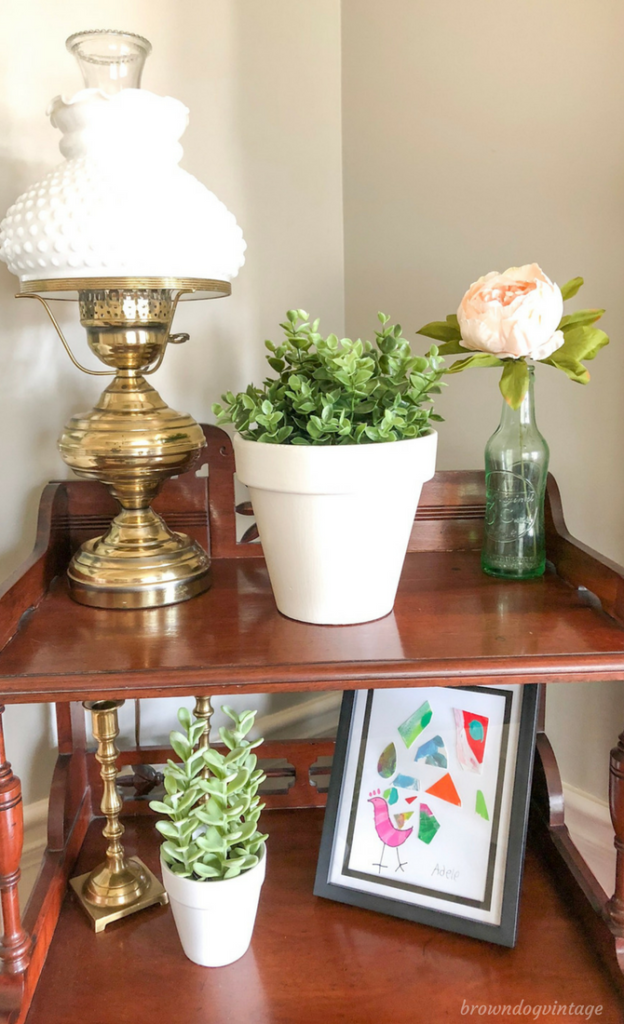 An antique side table with a white potted plant and decor.