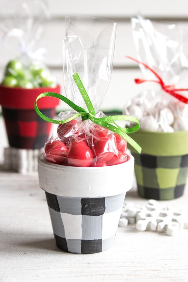 Buffalo check painted clay pots with Christmas gifts inside.