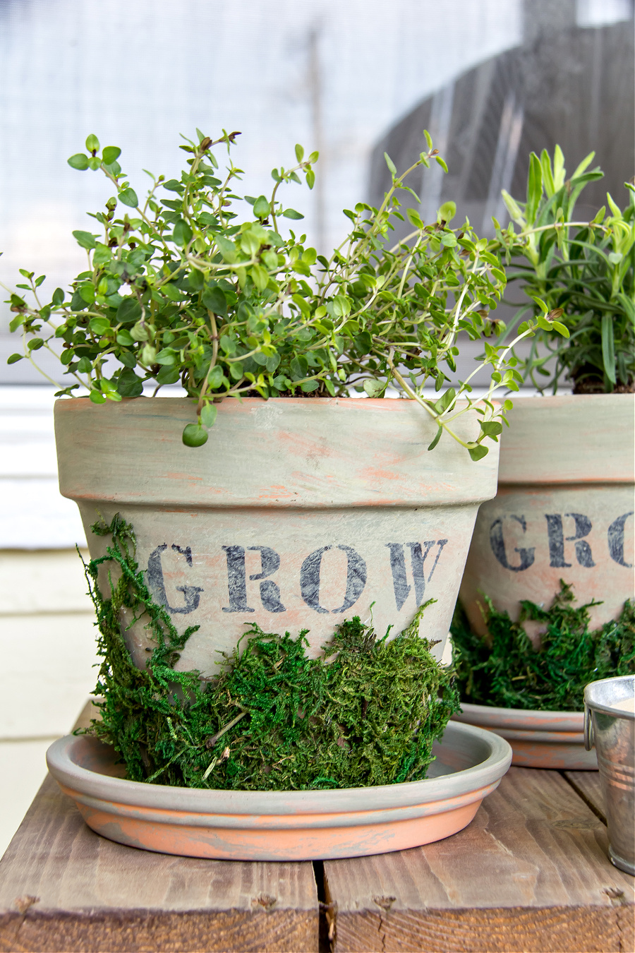 Herb pots with farmhouse paint design and moss decoration.
