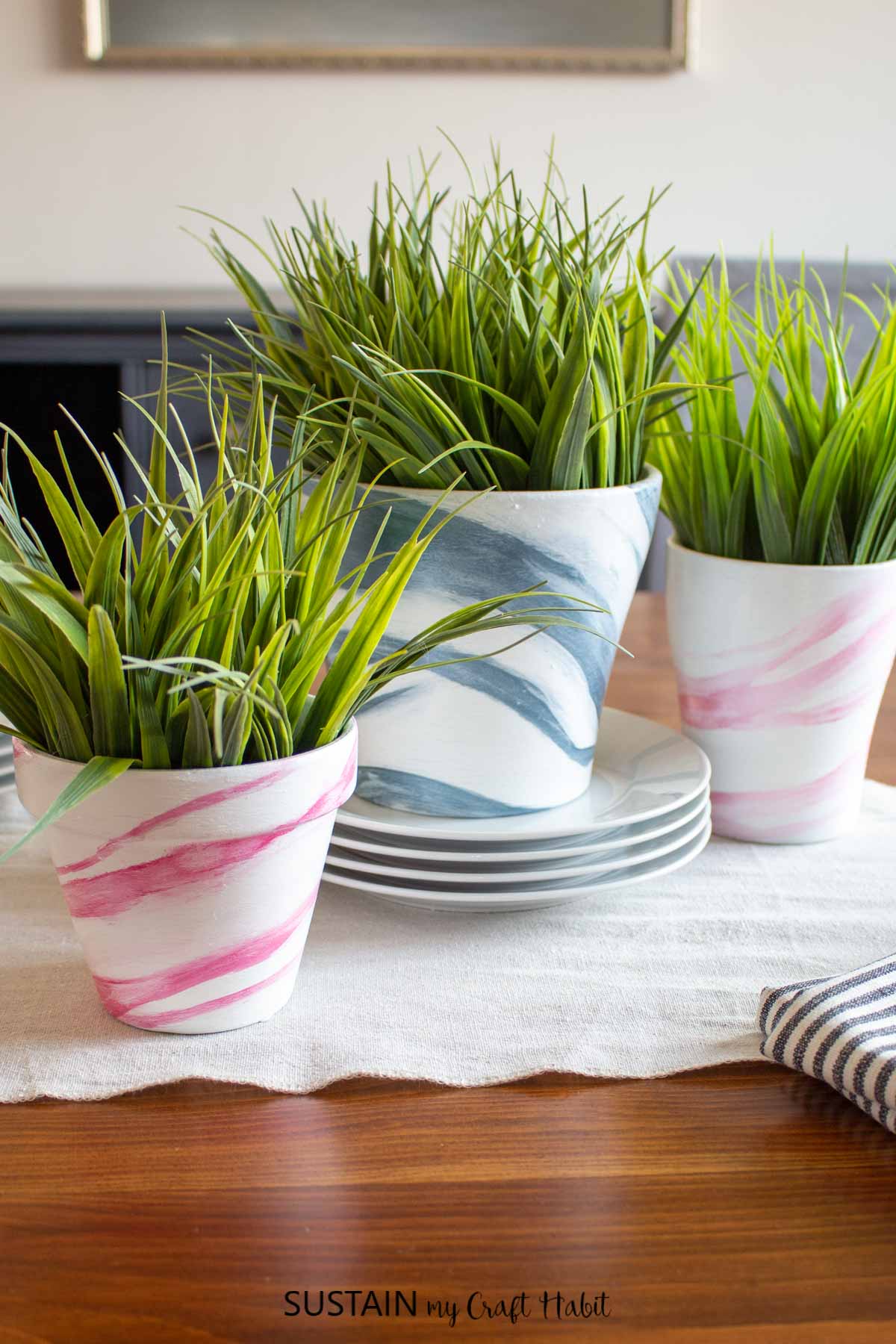 Marble painted clay potss with green plants inside.
