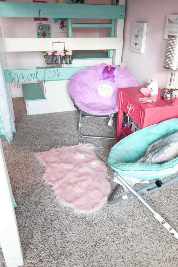 Two kid\'s chairs and a small table under a loft bed in a child\'s room.