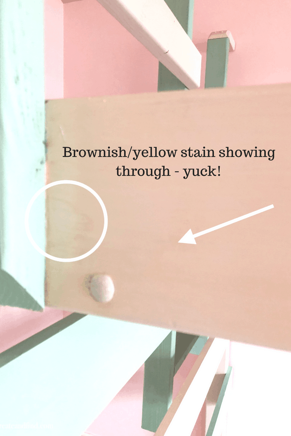 Closeup of wood with a circle and arrow and text overlay that reads \"Brownish/yellow stain showing through - yuck!\".