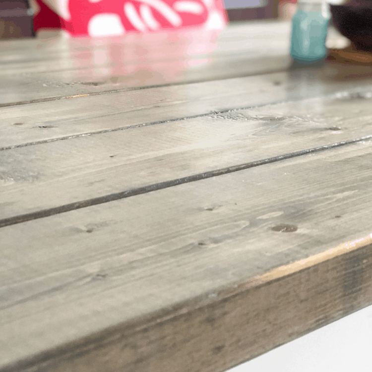 Close-up of a stained gray wood table top.