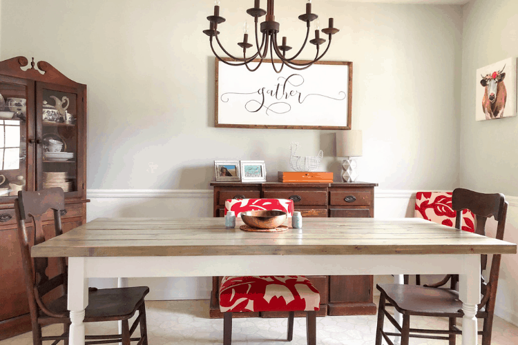 A farmhouse table in a dining room with a rustic chandelier. 