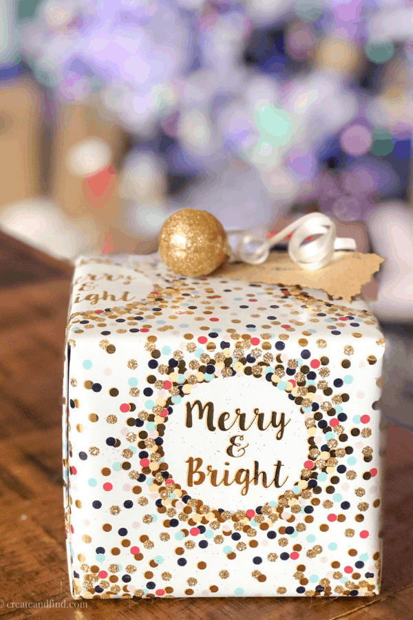 A Christmas present wrapped in white paper with colorful dots and the words \"Merry & Bright\".