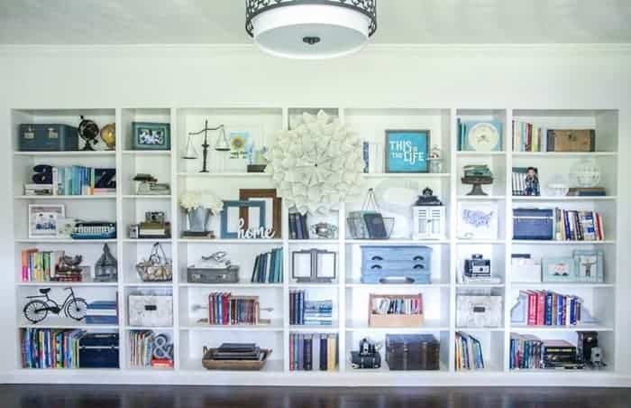 Built-in bookshelves filled with books and décor in a room with wooden floors.