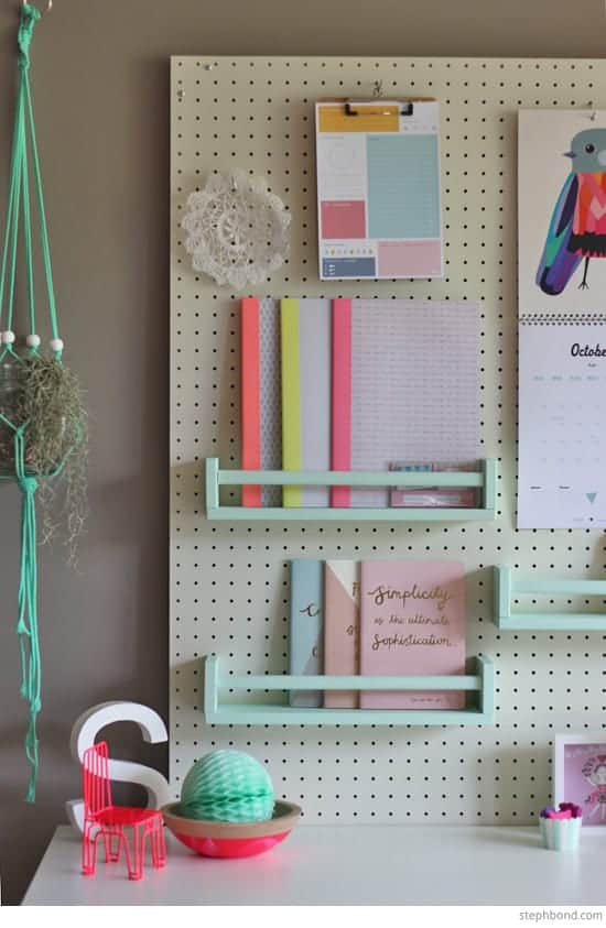 Pink and mint office wall décor and organization on a peg board.