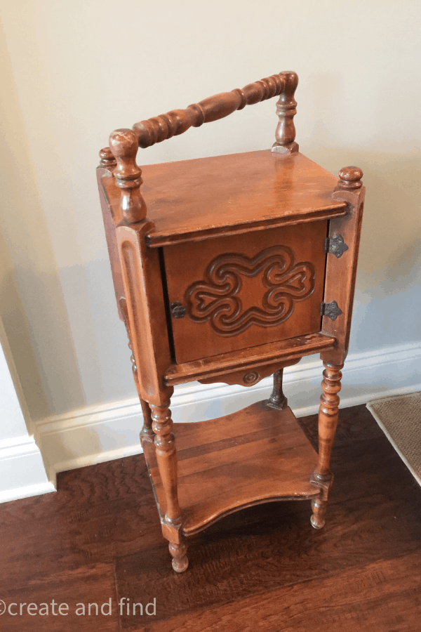 An a in antique cigar table next to the wall in a home before being painted.