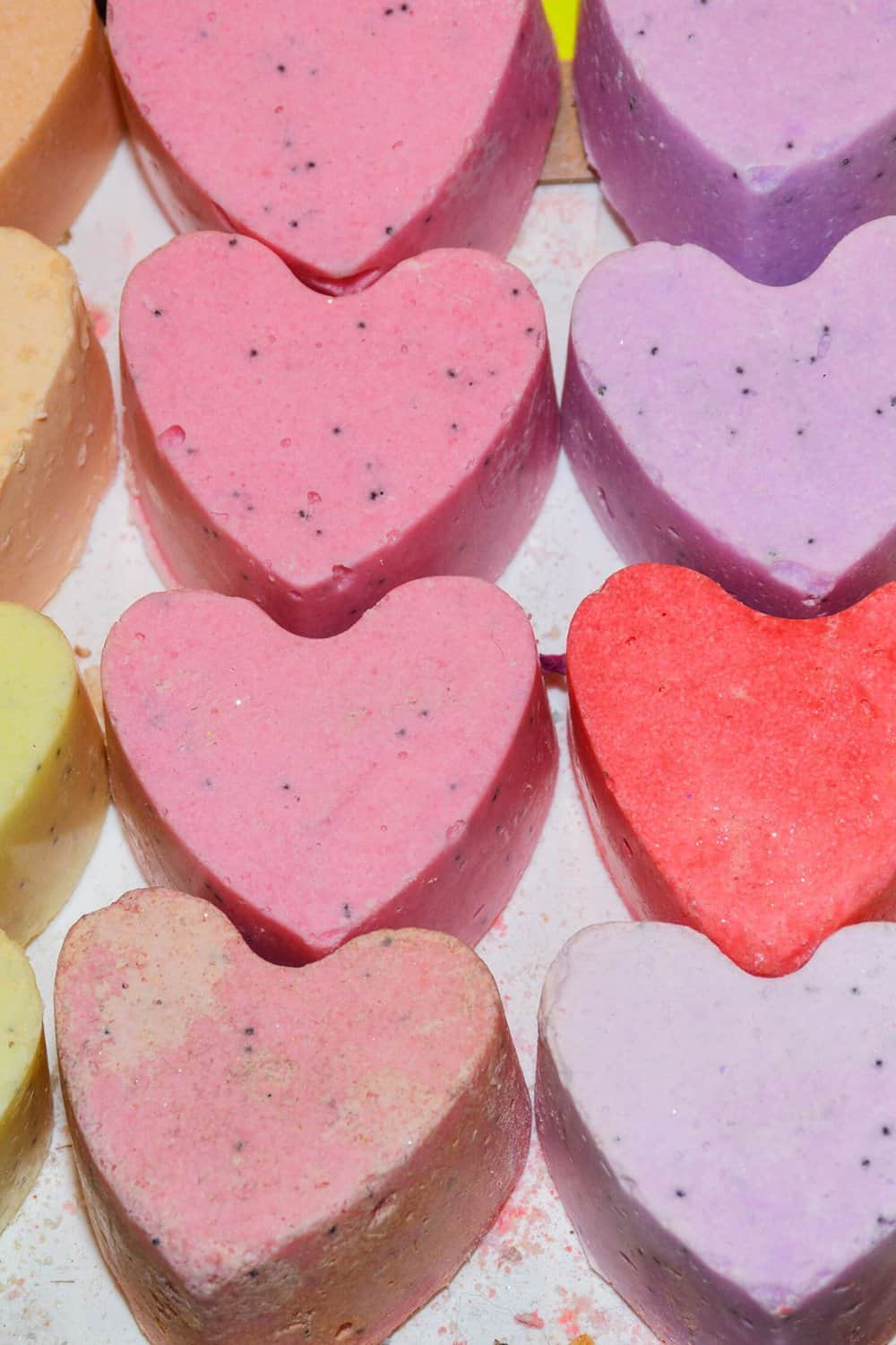 Several differently colored heart-shaped bath bombs.