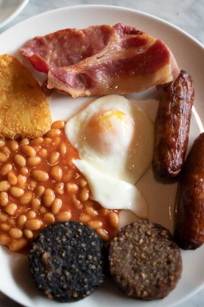 A full Irish breakfast with ham, sausage, eggs, cheese, and beans.
