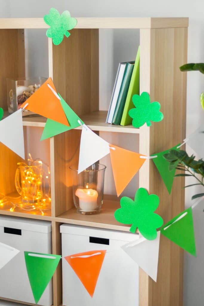 Green, orange, and white garland with shamrocks hanging in a living room.