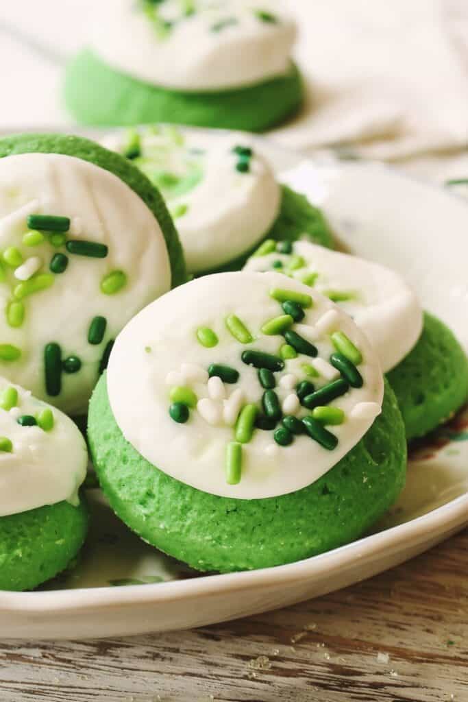 Fluffy green cookies with white icing and green sprinkles.