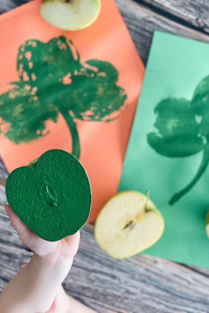 Apple-stamp shamrock St. Patrick's day craft for kids.