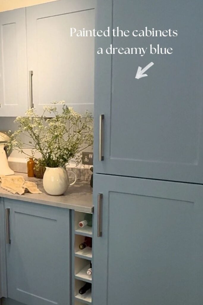 Blue painted kitchen cabinets wrapped in vinyl to protect the original finish.