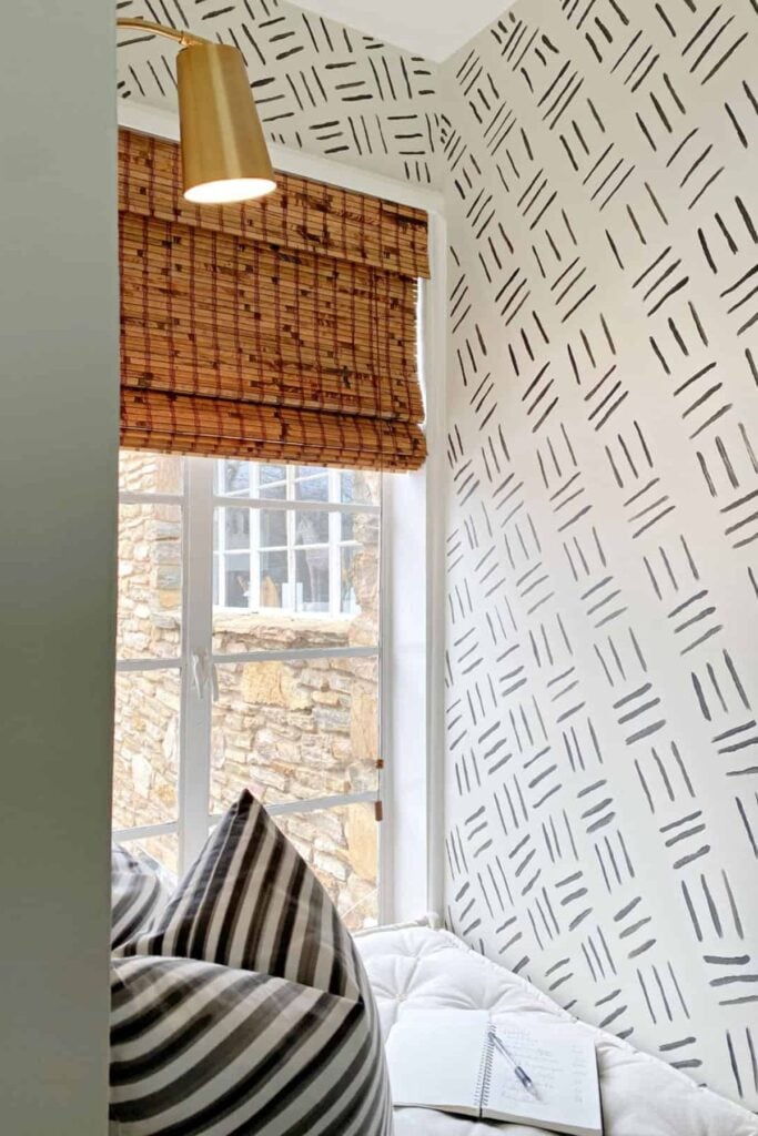 A boho line painted accent wall in a kid's bedroom window nook.