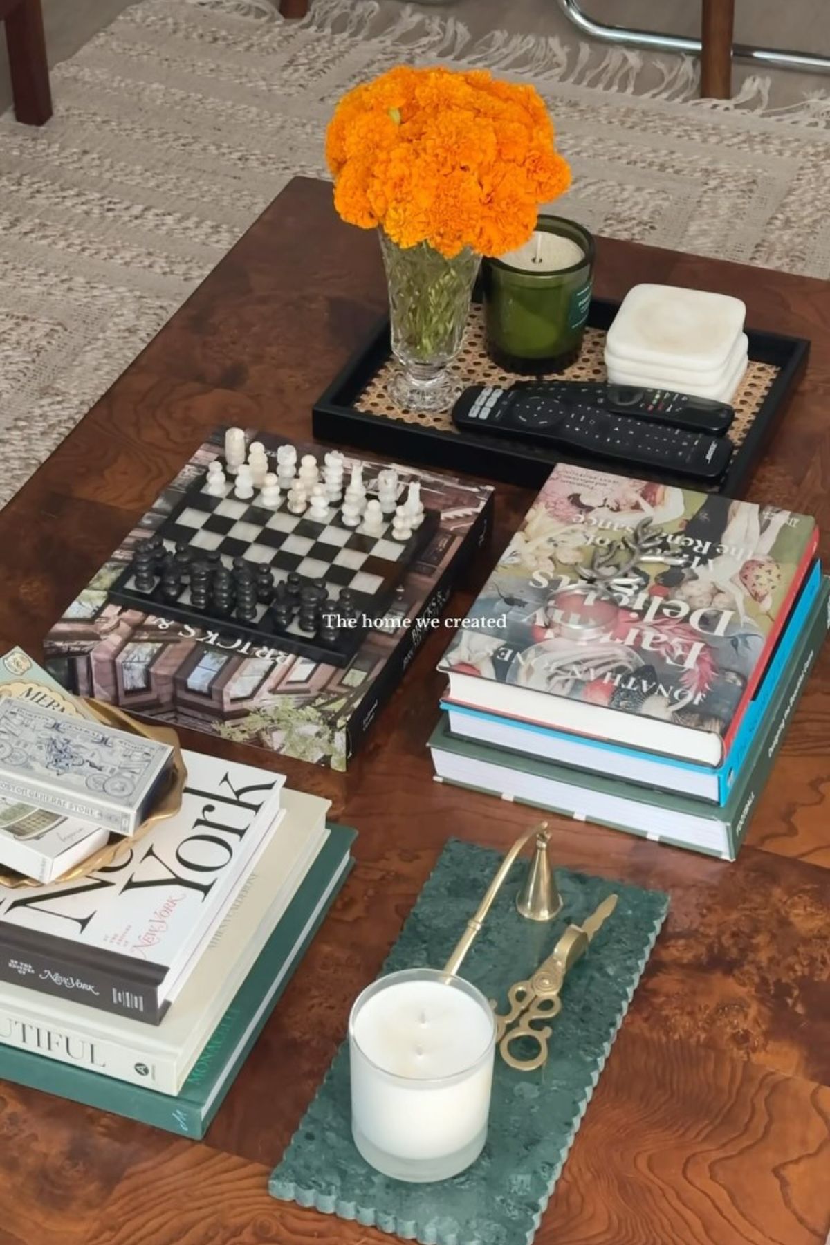 A decorated coffee table with book decor and a mini chess set.