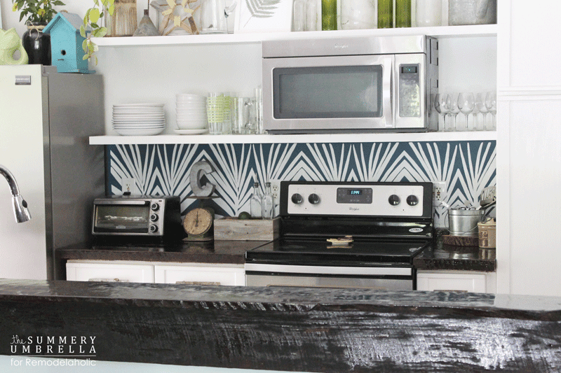Modern boho palm leaf painted kitchen backsplash with white and blue paint.