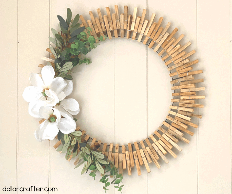 Magnolia clothespin wreath hanging on a wall.