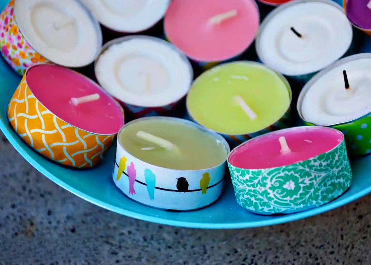Several tea lights wrapped in Washi tape with different patterns in a tray.