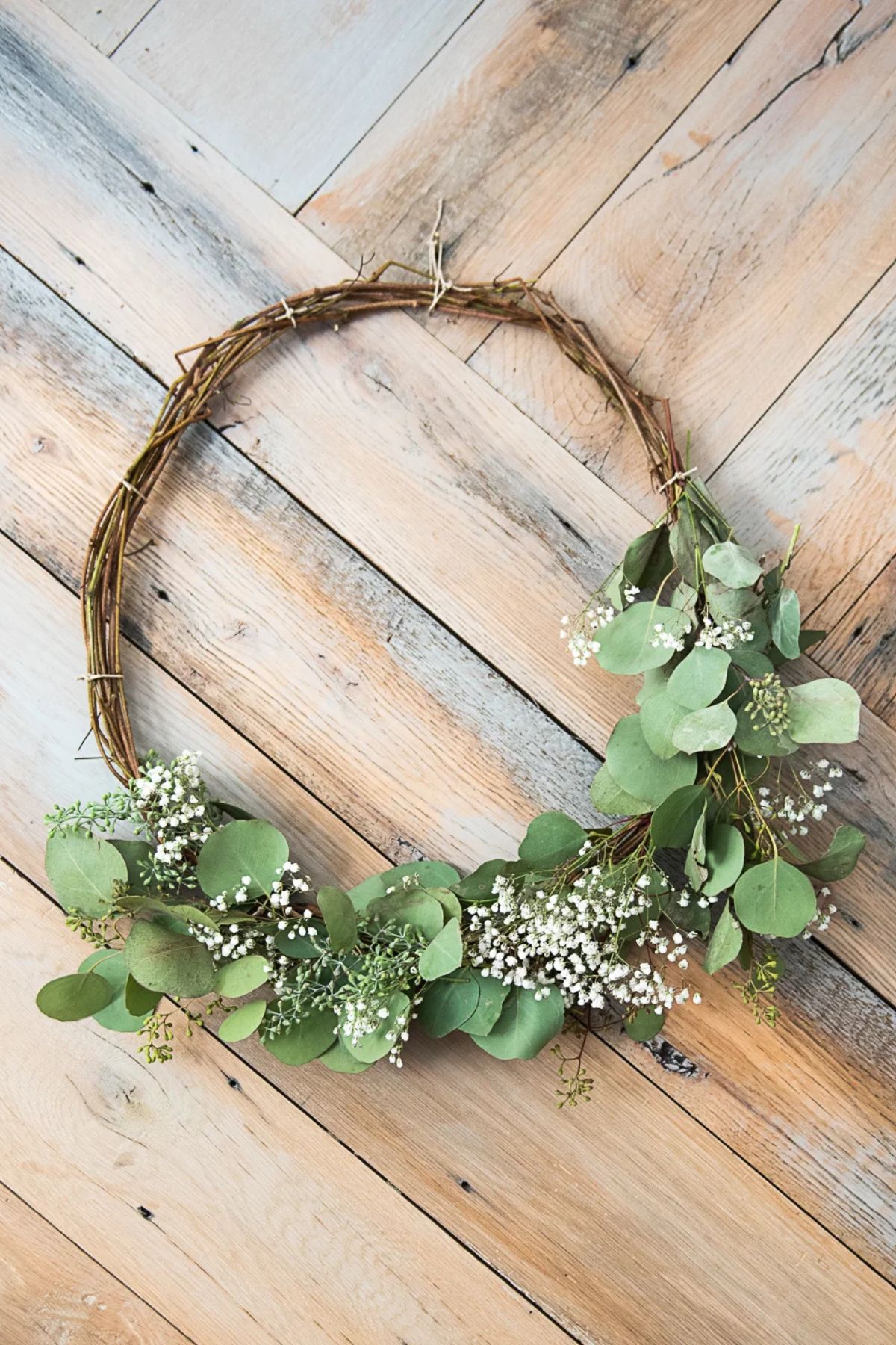 A DIY eucalyptus wreath on a wood background.