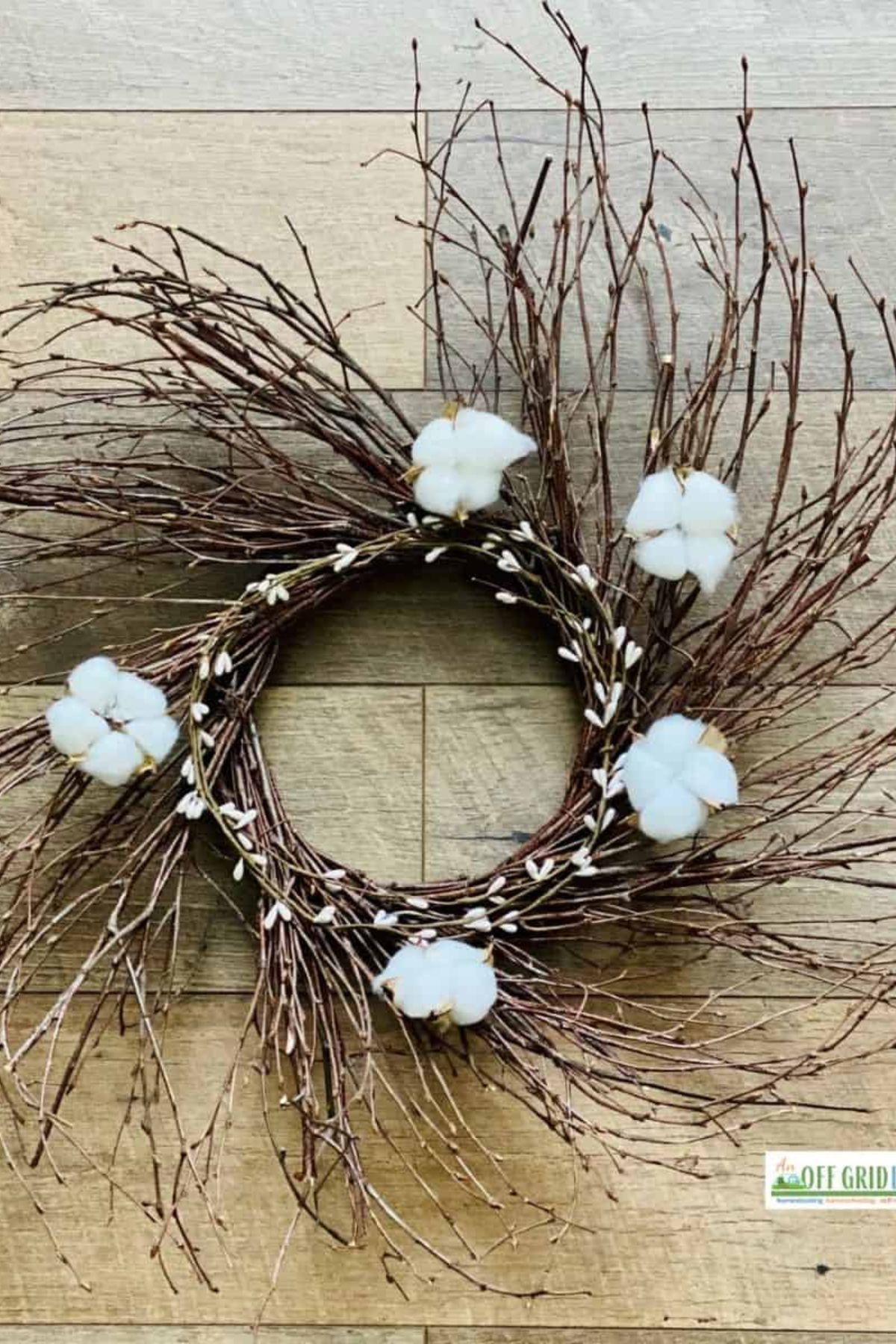 A rustic wreath with cotton on a wood background.