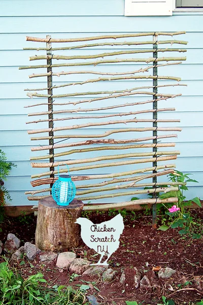 A tree branch garden trellis against the outside wall of a house.