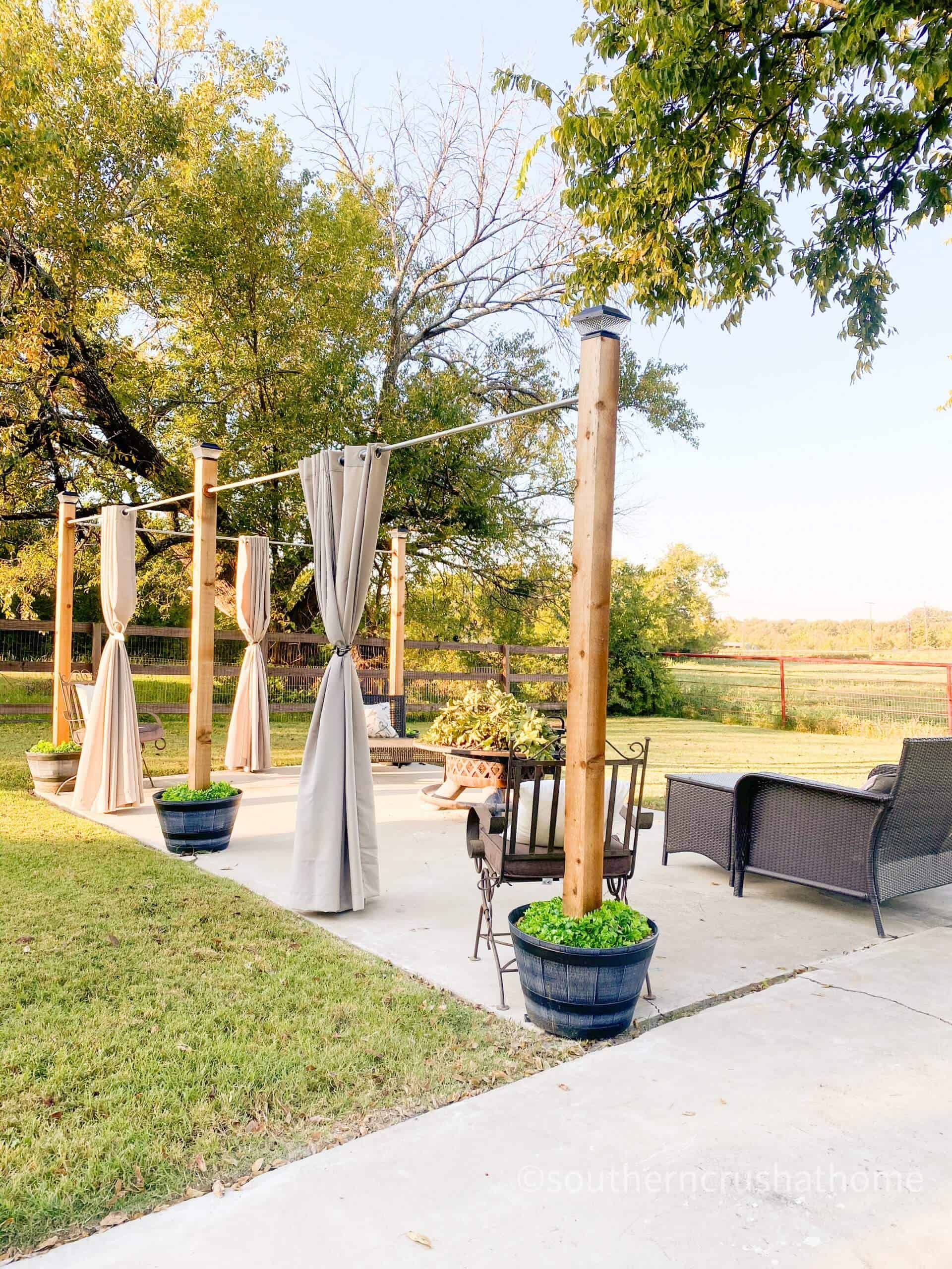 DIY outdoor patio curtains and string lights built into planters.