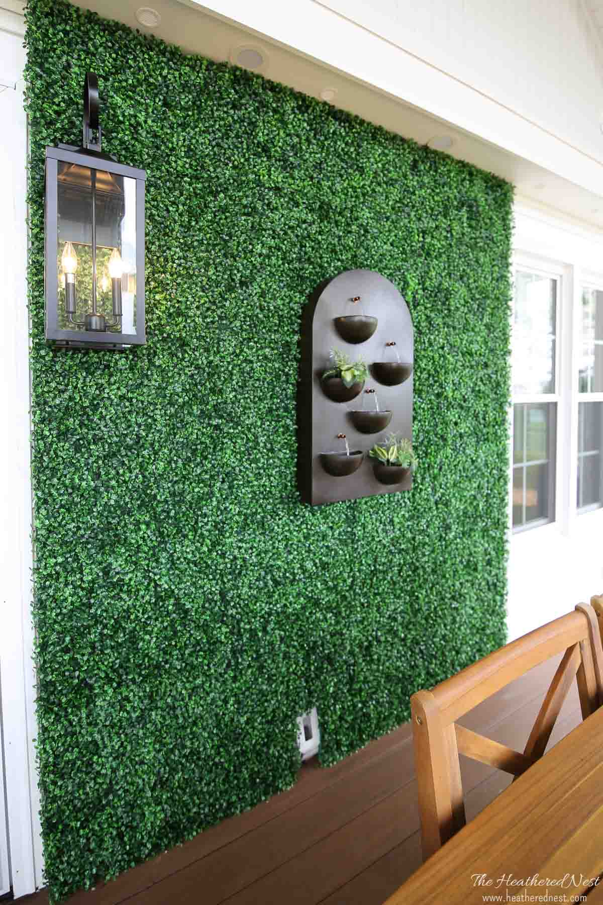 A faux boxwood wall on the exterior wall of a house.
